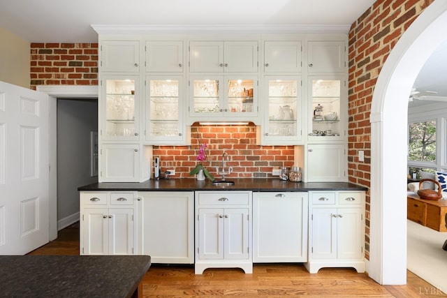 3830 Peakland Pl, Lynchburg, VA 24503 - bar featuring arched walkways, brick wall, light wood-type flooring, and a sink