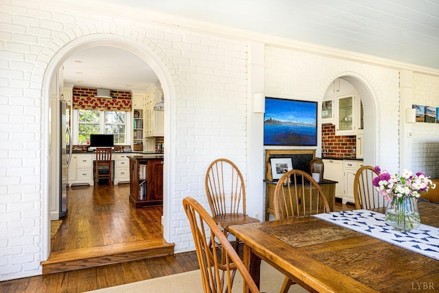 3830 Peakland Pl, Lynchburg, VA 24503 - dining area with dark wood-type flooring, arched walkways, and brick wall