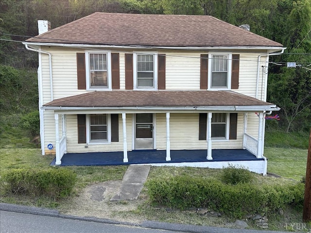 view of front of property featuring a chimney, roof with shingles, and a porch