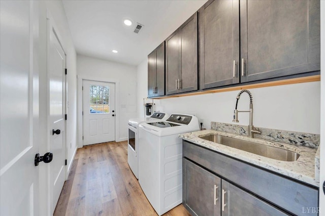 9900 Stonewall Rd, Appomattox, VA 24522 - washroom with a sink, washing machine and dryer, light wood-type flooring, recessed lighting, and cabinet space