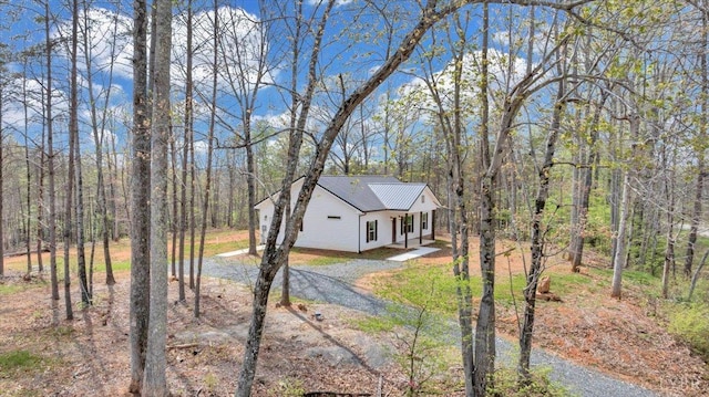 9900 Stonewall Rd, Appomattox, VA 24522 - view of front of house featuring dirt driveway, a forest view, and metal roof