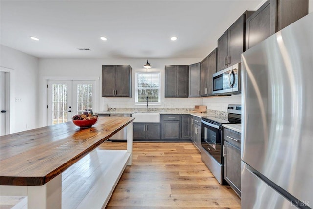 9900 Stonewall Rd, Appomattox, VA 24522 - kitchen with stainless steel appliances, french doors, a sink, butcher block counters, and decorative backsplash
