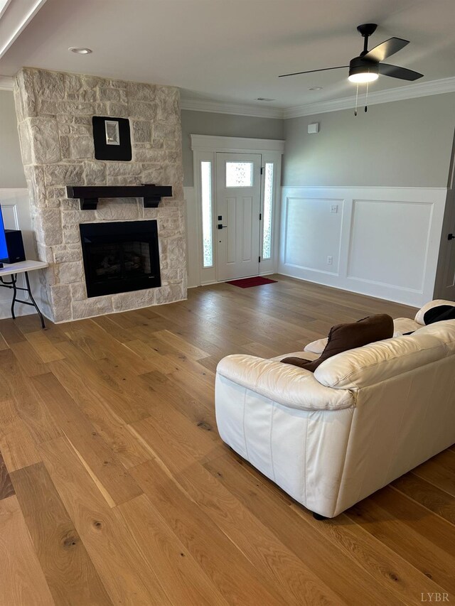 1022 N Westyn Loop, Forest, VA 24551 - living room with crown molding, a fireplace, a ceiling fan, wood finished floors, and a wainscoted wall