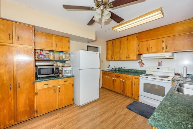 139 Old Main St, Brookneal, VA 24528 - kitchen with white appliances, under cabinet range hood, light wood-type flooring, brown cabinets, and a ceiling fan