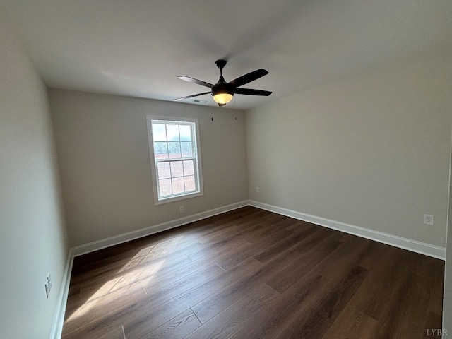 empty room featuring dark wood-style floors, baseboards, and a ceiling fan