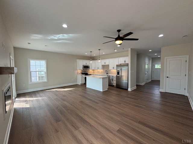 unfurnished living room with baseboards, recessed lighting, dark wood-style flooring, and ceiling fan