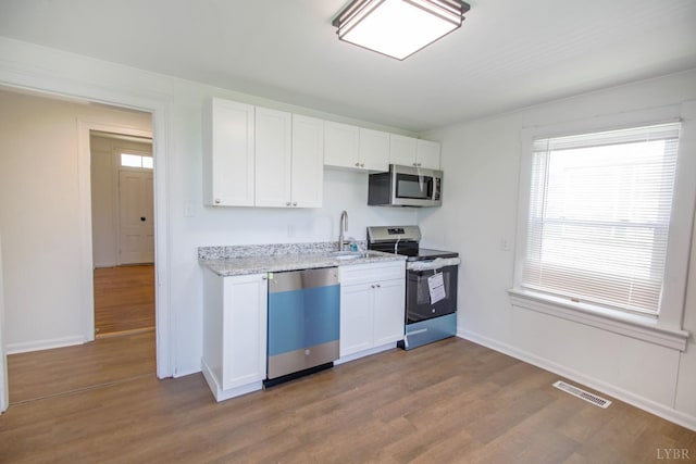 1518 14th St, Lynchburg, VA 24501 - kitchen with stainless steel appliances, dark wood-style floors, white cabinets, and light stone counters