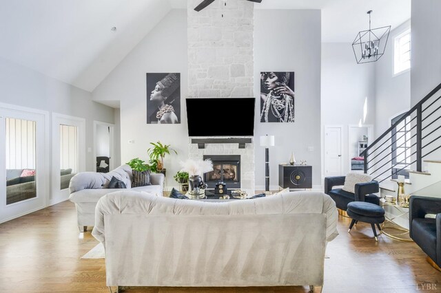 301 Bentley Grove Way, Lynchburg, VA 24502 - living area with high vaulted ceiling, wood finished floors, stairs, a stone fireplace, and a chandelier