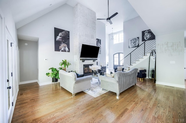 301 Bentley Grove Way, Lynchburg, VA 24502 - living room featuring high vaulted ceiling, stairway, light wood finished floors, ceiling fan, and a stone fireplace