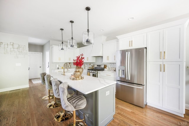 301 Bentley Grove Way, Lynchburg, VA 24502 - kitchen with stainless steel appliances, white cabinetry, tasteful backsplash, a kitchen island with sink, and a breakfast bar