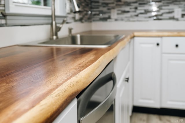 3677 Grit Rd, Hurt, VA 24563 - kitchen view of a sink, white cabinetry, wooden counters, and dishwasher