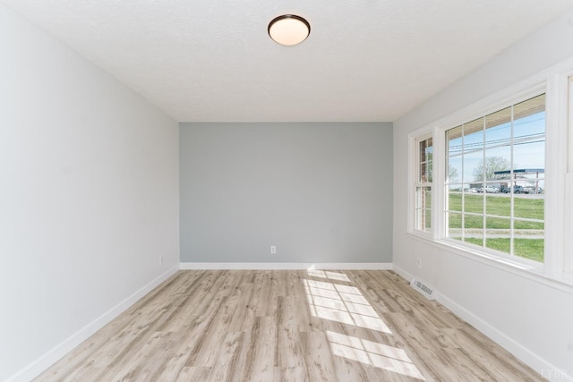 3677 Grit Rd, Hurt, VA 24563 - empty room featuring light wood-style flooring, baseboards, and a textured ceiling