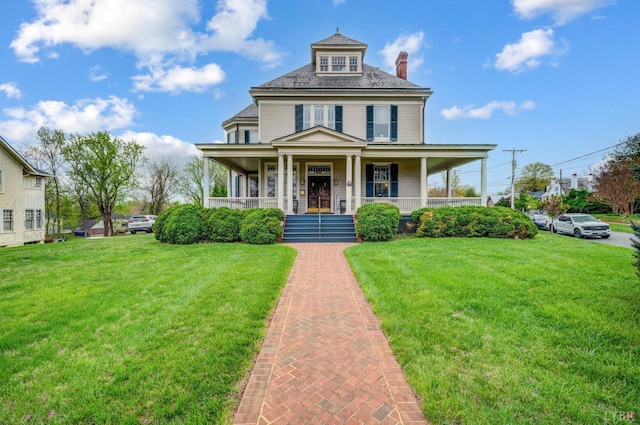 view of front of home featuring a chimney, a front yard, and covered porch