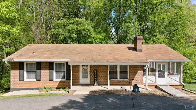 119 Adams Dr, Lynchburg, VA 24502 - view of front of house featuring a chimney, a sunroom, brick siding, and a shingled roof