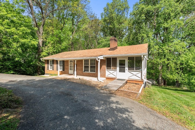 119 Adams Dr, Lynchburg, VA 24502 - ranch-style home featuring brick siding, a chimney, a front yard, and asphalt driveway