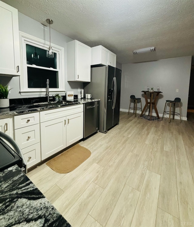 1172 Golden Leaf Rd, Nathalie, VA 24577 - kitchen with dishwashing machine, black fridge with ice dispenser, a textured ceiling, light wood-style floors, and white cabinets