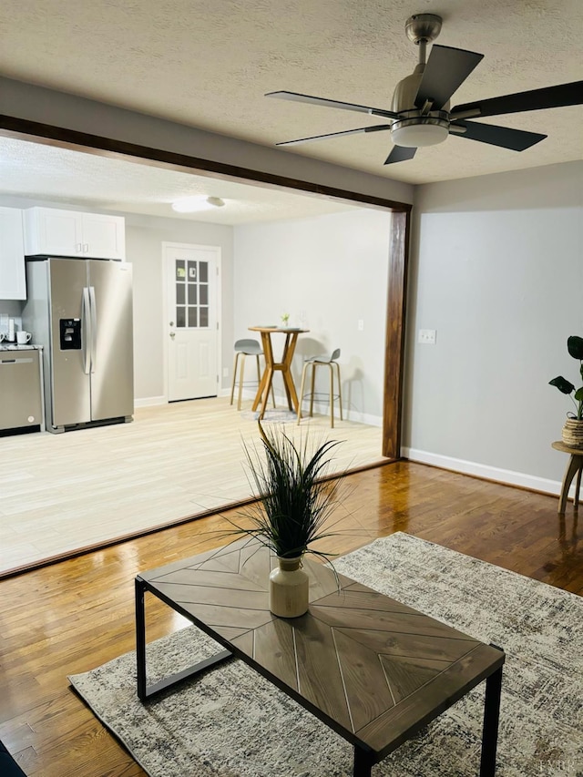 1172 Golden Leaf Rd, Nathalie, VA 24577 - living area with baseboards, a textured ceiling, ceiling fan, and light wood-style flooring