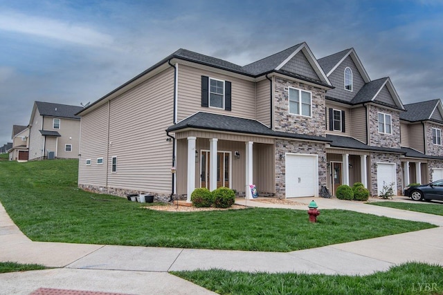 craftsman house featuring an attached garage, stone siding, driveway, and a front yard