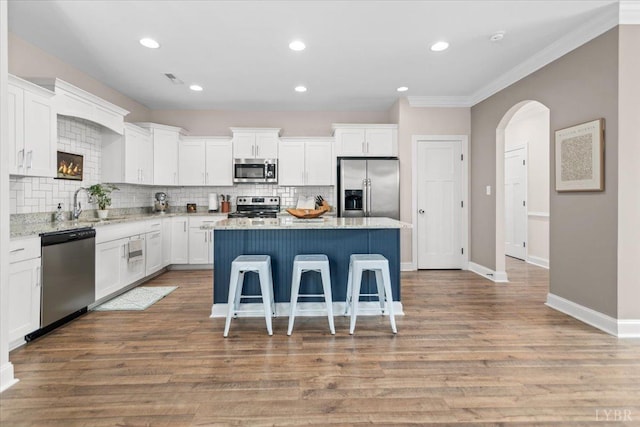 kitchen with a sink, tasteful backsplash, a kitchen island, and stainless steel appliances