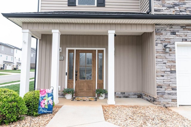 property entrance with a porch and stone siding