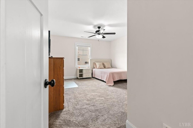 carpeted bedroom featuring baseboards and ceiling fan