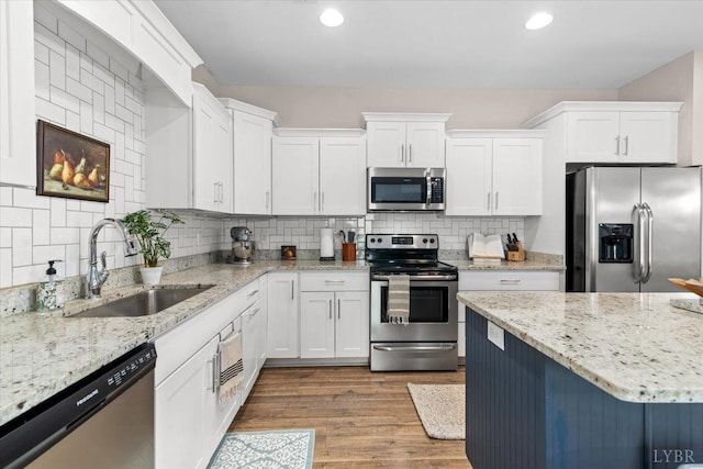 kitchen with a sink, white cabinetry, appliances with stainless steel finishes, and tasteful backsplash