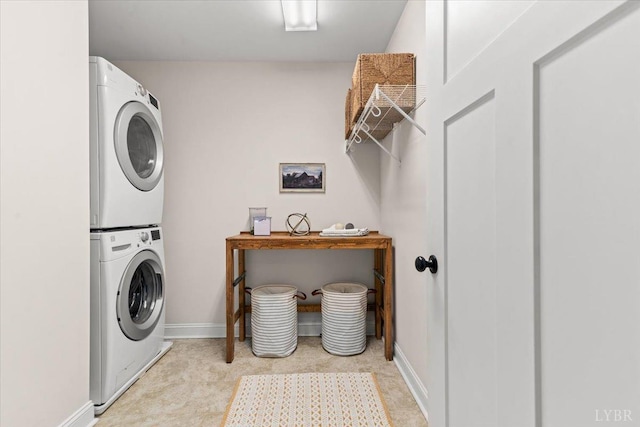 laundry area with laundry area, stacked washer and clothes dryer, and baseboards