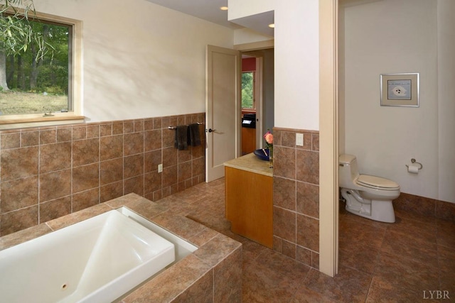 1209 Sycamore Creek Dr, Goode, VA 24556 - bathroom with a relaxing tiled tub, a wainscoted wall, toilet, and tile walls