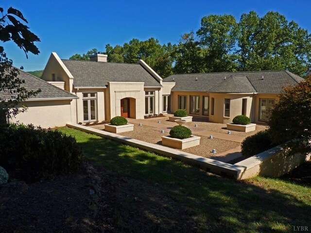 1209 Sycamore Creek Dr, Goode, VA 24556 - rear view of house with an outdoor structure, a chimney, a yard, and stucco siding