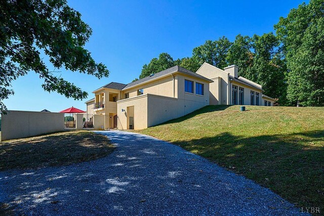 1209 Sycamore Creek Dr, Goode, VA 24556 - view of front of home with fence, stucco siding, a chimney, and a front lawn