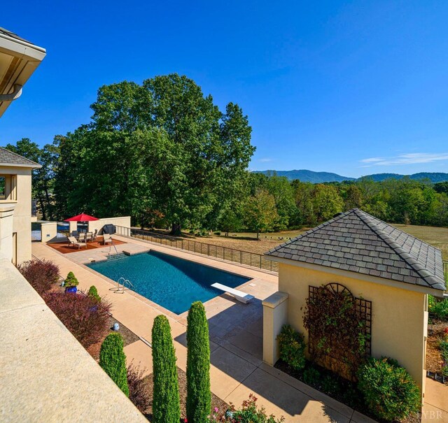 1209 Sycamore Creek Dr, Goode, VA 24556 - view of pool with fence, a diving board, a fenced in pool, a mountain view, and a patio area