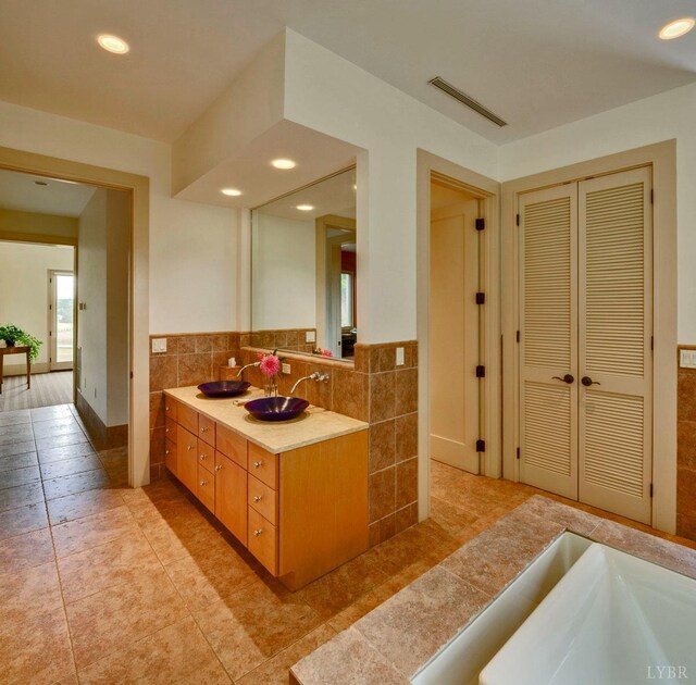 1209 Sycamore Creek Dr, Goode, VA 24556 - bathroom featuring a sink, tile patterned flooring, recessed lighting, tile walls, and visible vents