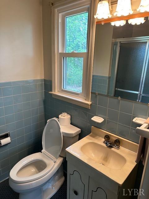 116 Carson St, Brookneal, VA 24528 - bathroom with tile walls, a stall shower, toilet, vanity, and a wainscoted wall