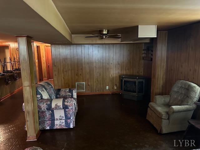 116 Carson St, Brookneal, VA 24528 - living area featuring wood walls, a wood stove, and a ceiling fan