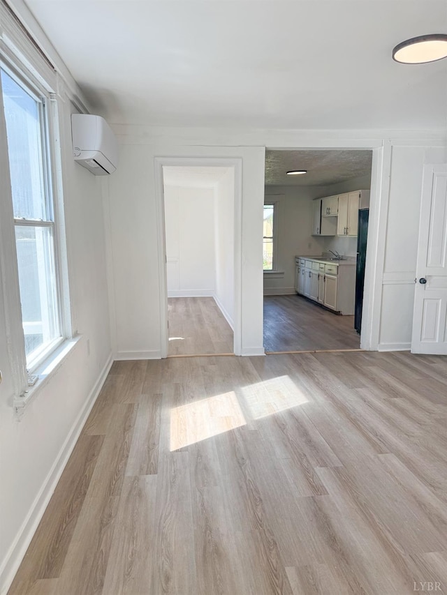 1305 Campbell Ave, Lynchburg, VA 24501 - unfurnished dining area featuring light wood finished floors, a wall mounted air conditioner, plenty of natural light, and baseboards