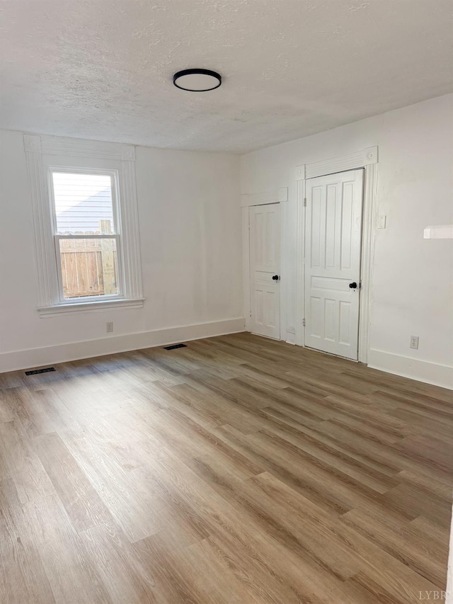 1305 Campbell Ave, Lynchburg, VA 24501 - spare room featuring light wood-style flooring, baseboards, and a textured ceiling