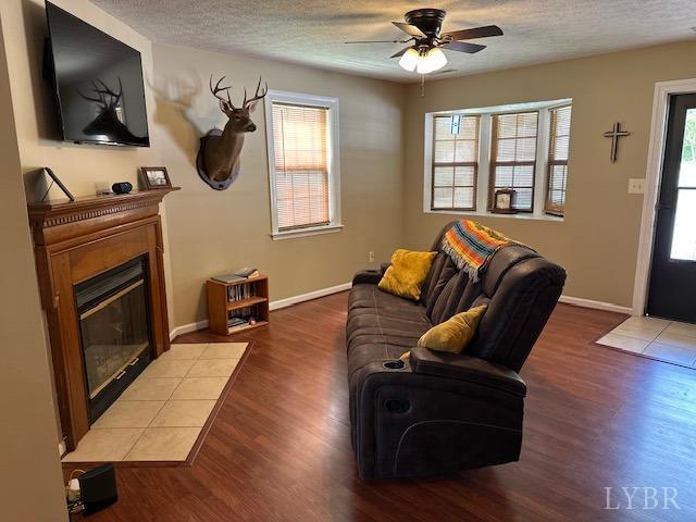 301 Gooseneck Ct, Forest, VA 24551 - living area with a tiled fireplace, healthy amount of natural light, wood finished floors, and a textured ceiling