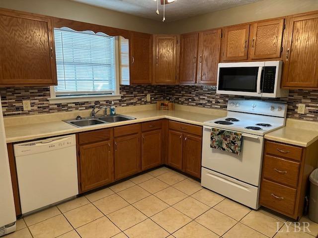 301 Gooseneck Ct, Forest, VA 24551 - kitchen featuring white appliances, a sink, backsplash, light countertops, and light tile patterned flooring