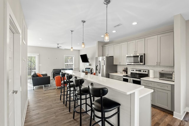 21 Zags Ln, Lynchburg, VA 24502 - kitchen with stainless steel appliances, gray cabinetry, open floor plan, a kitchen bar, and backsplash