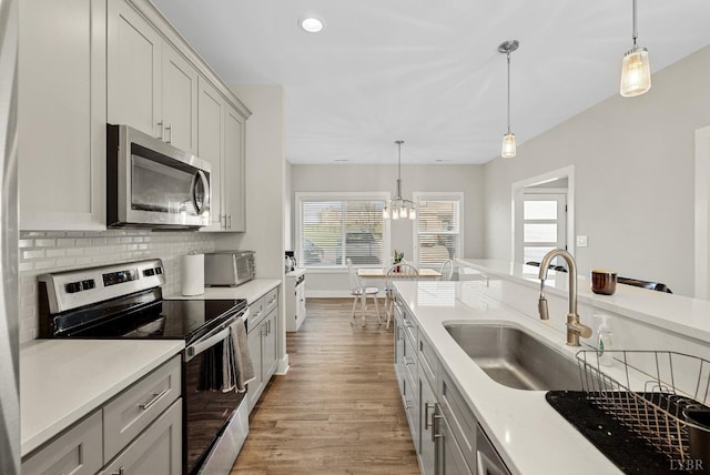 21 Zags Ln, Lynchburg, VA 24502 - kitchen with stainless steel appliances, wood finished floors, a sink, light countertops, and backsplash