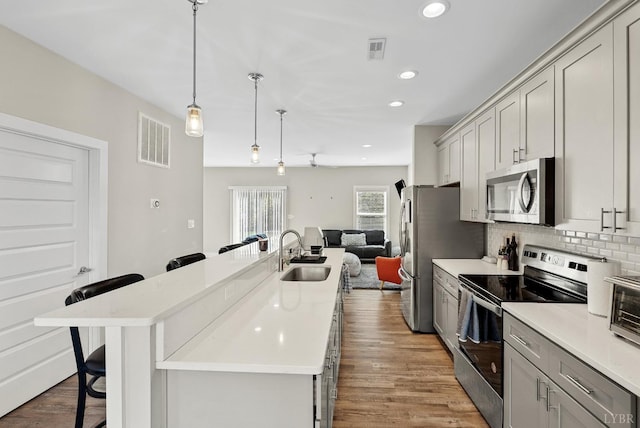 21 Zags Ln, Lynchburg, VA 24502 - kitchen with appliances with stainless steel finishes, a breakfast bar area, a sink, an island with sink, and tasteful backsplash