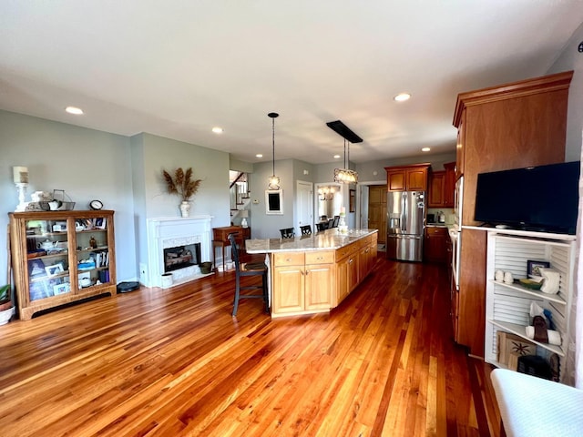 216 Burford Farm Rd, Monroe, VA 24574 - kitchen with stainless steel fridge with ice dispenser, light countertops, a kitchen breakfast bar, wood finished floors, and recessed lighting