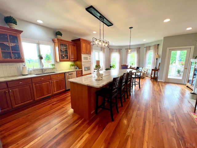 216 Burford Farm Rd, Monroe, VA 24574 - kitchen featuring white appliances, a kitchen breakfast bar, brown cabinets, dark wood finished floors, and a kitchen island