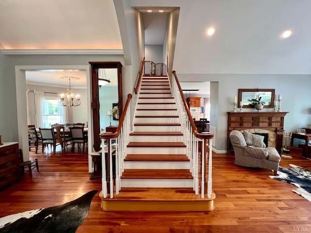 216 Burford Farm Rd, Monroe, VA 24574 - stairs featuring wood finished floors, a chandelier, a fireplace, and ornamental molding