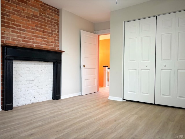 850 Rivermont Ave, Lynchburg, VA 24504 - unfurnished bedroom featuring wood finished floors, a closet, baseboards, and a fireplace