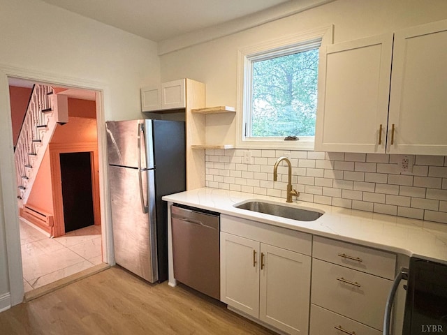 850 Rivermont Ave, Lynchburg, VA 24504 - kitchen featuring appliances with stainless steel finishes, a sink, baseboard heating, light wood finished floors, and tasteful backsplash