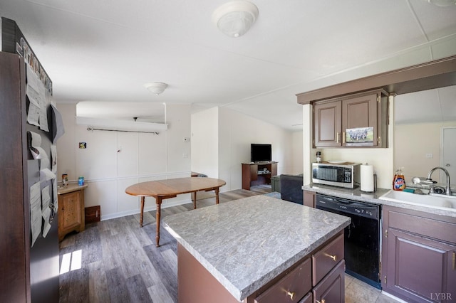 113 Carwile Rd, Rustburg, VA 24588 - kitchen with stainless steel microwave, light wood-style floors, black dishwasher, light countertops, and a sink