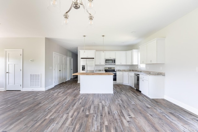 243 Pebble Rd, Rustburg, VA 24588 - kitchen with stainless steel appliances, a sink, baseboards, wood finished floors, and white cabinetry