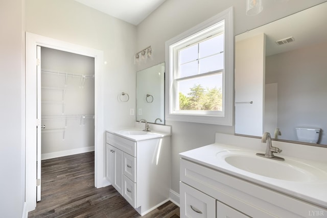 243 Pebble Rd, Rustburg, VA 24588 - bathroom with two vanities, wood finished floors, baseboards, and a walk in closet