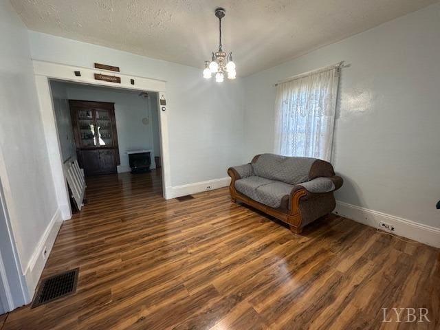 2107 SE Kenwood Blvd, Roanoke, VA 24013 - living area featuring wood finished floors, baseboards, a chandelier, and a textured ceiling